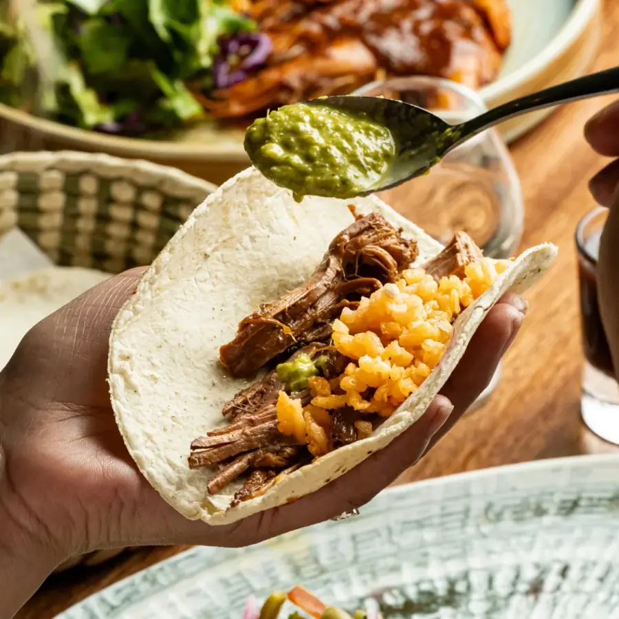 Taco de carne deshebrada con arroz y salsa verde